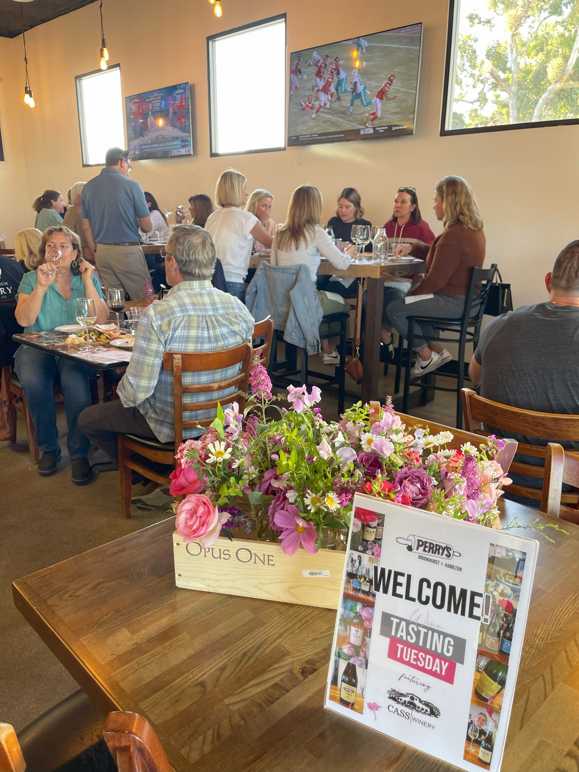 photo of customers sitting at tables while they attend a wine tasting