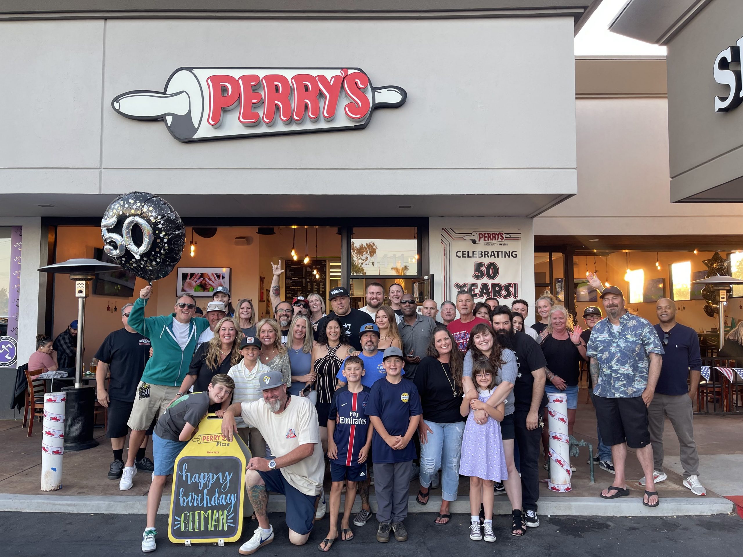 people gather outside of the front of perrys restaurant after celebrating a birthday